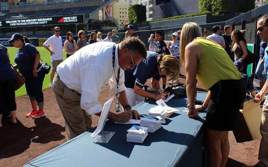 J.J. Quinn, a military advisor for the San Diego Padres, writes a note to deployed troops during a care package packing party Wednesday at Petco Park. Players and Padres staff worked with an insurance agency to assemble and send 1,000 care packages to deployed Marines and sailors with I Marine Expeditionary Force.