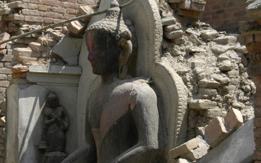 A statue of Buddha sits intact among earthquake debris in Bhaktapur, Nepal,  Tuesday, May 5, 2015.