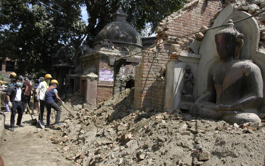 Workers clear rubble from an earthquake damaged religious site at Bhaktapur, Nepal, on Tuesday, May 5, 2015. The death toll from the 7.9 magnitude earthquake that struck April 25 has passed 7,500.