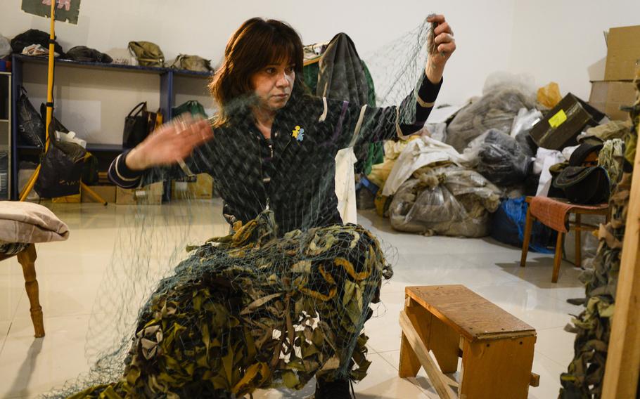 Oksana Stryzhevska, who belongs to a group called the Net Battalion, sorts out material to make camouflage nets for Ukrainian soldiers.