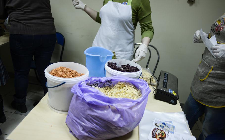 Ukrainian volunteers vacuum-pack dried ingredients to make Borscht for Ukrainian soldiers fighting against Russian-backed separatists.