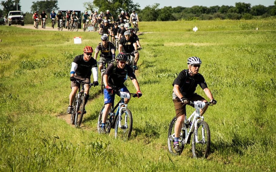 Former President George W. Bush leads current or former military service members on the W100K mountain bike ride across his ranch in Crawford, Texas, May 1, 2015. The 17 participants on this year?s ride were all wounded while serving in the global war on terror, and were invited to participate in this three-day event that covers 100 kilometers on and around the ranch.