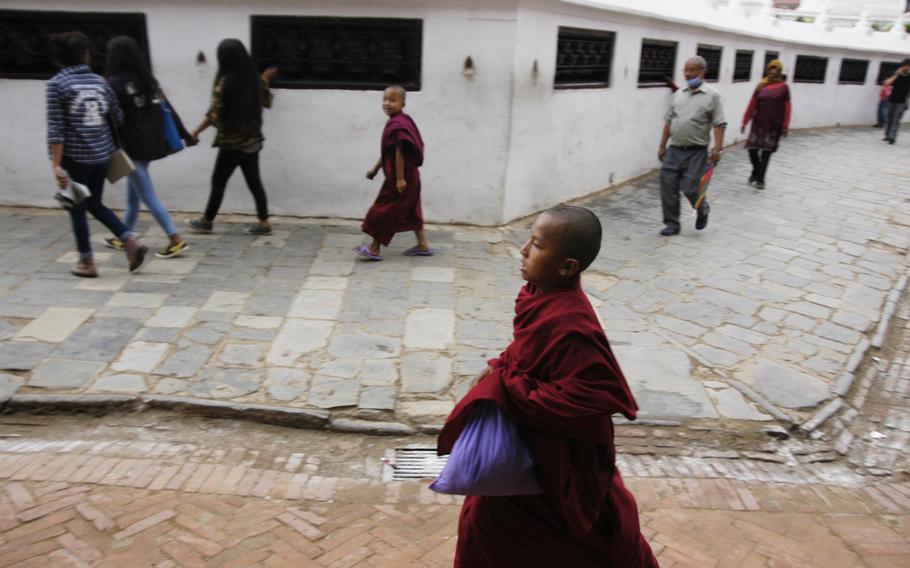 A young Buddhist monk passes the Boudhanath Stupa in Kathmandu, Nepal,  on May 9, 2015. The Tibetan temple was a popular destination for earthquake relief workers on their way out of town.