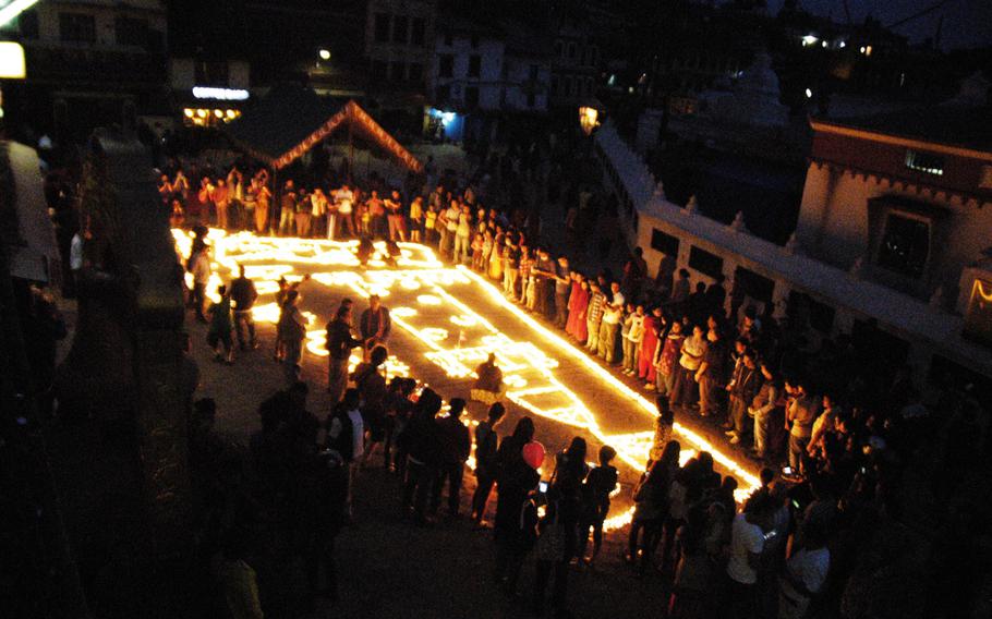 Nepalese Buddhists light candles at the Boudhanath Stupa in Kathmandu on May 9, 2015.
