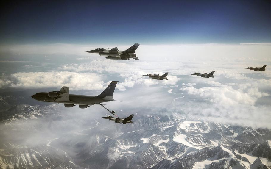 F-16 Fighting Falcons from the 18th Aggressor Squadron at Eielson Air Force Base, Alaska, refuel behind a KC-135 Stratotanker assigned to the Pennsylvania Air National Guard's 171st Air Refueling Wing, while flying over the Joint Pacific Alaska Range Complex on May 11, 2015, during Red Flag-Alaska 15-2.