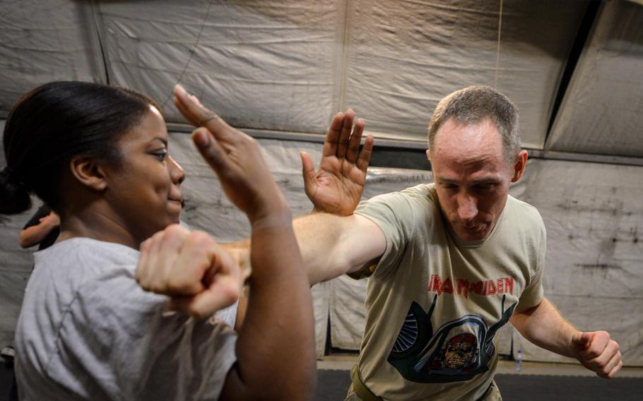 Senior Airman Tiffany Hamilton, 455th Expeditionary Medical Operations Squadron medical technician, and Lt. Col. Paul Cory, 817th Expeditionary Air Support Operations Squadron commander, practice Krav Maga techniques during a bi-weekly class at Bagram Air Field, Afghanistan, May 7, 2015.