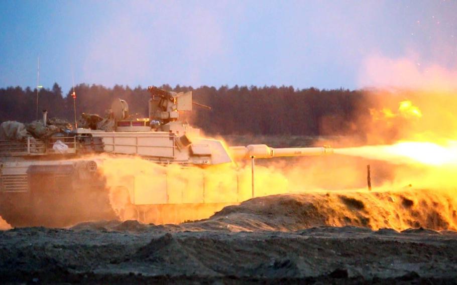 The crew of an M1A2 Abrams Main Battle Tank fires the main gun at a target during the night portion of gunnery training May 8, 2015, at the Camp Konotop, Poland, Range Complex. The soldiers, assigned to 7th Infantry Regiment, 1st Armored Brigade Combat Team, 3rd Infantry Division, are taking part in Operation Atlantic Resolve.