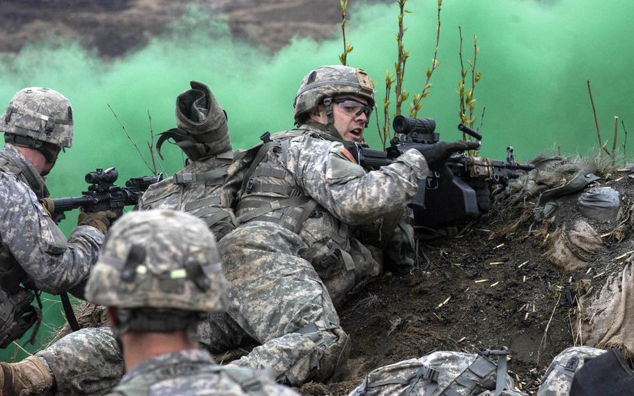 A machine gunner with 3rd Battalion (Airborne) 509th Infantry Regiment reports his status during a Combined Arms Maneuver Live Fire Exercise at Joint Base Elmendorf-Richardson, Alaska, May 8, 2015. The exercise was part of the 4th Infantry Brigade Combat Team (Airborne), 25th Infantry Division exercise Spartan Phoenix.