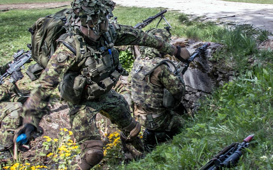 An Estonian soldier throws a dummy grenade at British forces after the defense of Oandu, Estonia, during Operation Siil, May 12, 2015. For the exercise, British and American forces were fighting alongside and against Estonian forces. Operation Siil is the largest training exercise ever held in Estonia and features more than 12,000 soldiers from six nations. \