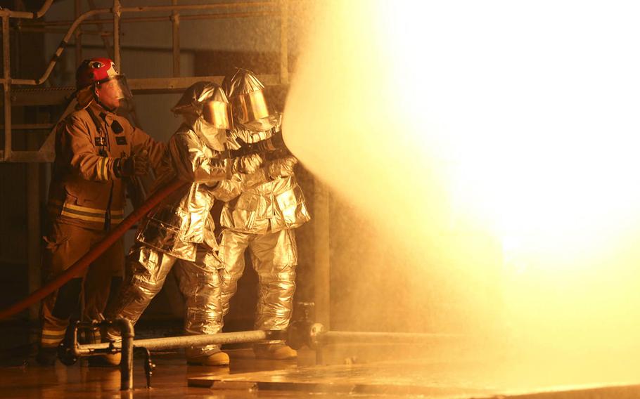 Marines with Marine Wing Support Squadron 171, Marine Rotational Force ? Darwin, and an Australian firefighter with Aviation Rescue Firefighting Service, Airservices Australia, Darwin International Airport, practice extinguishing controlled chemical fires May 11, 2015, at RAFF Base Darwin, Darwin, Northern Territory, Australia.
