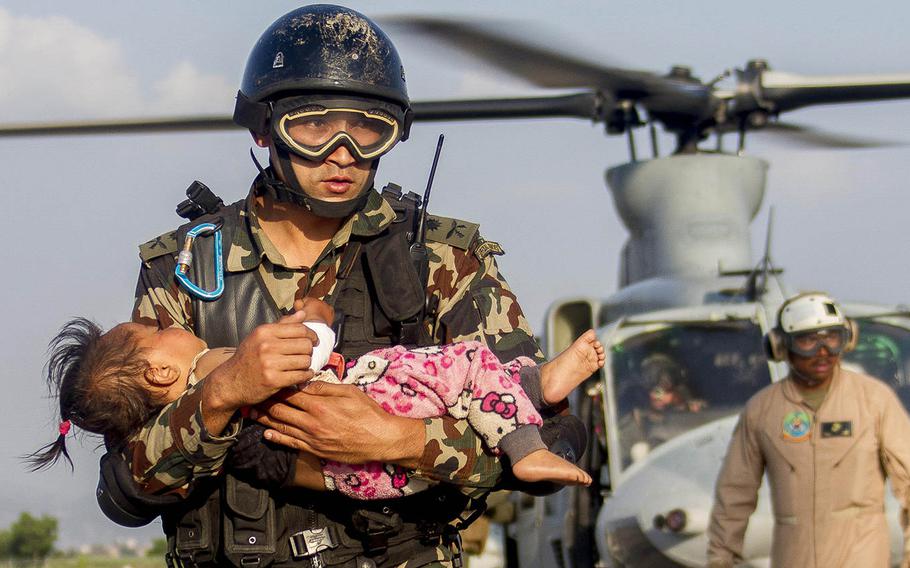 A Nepalese soldier carries a young earthquake victim from a U.S. Marine Corps UH-1Y Venom helicopter assigned to Joint Task Force 505 to a medical triage area at Tribhuvan International Airport, Kathmandu, Nepal, after a 7.3 magnitude earthquake struck the country, May 12, 2015. Joint Task Force 505 along with other multinational forces and humanitarian relief organizations are currently in Nepal providing aid after a 7.8 magnitude earthquake struck the country April 25.