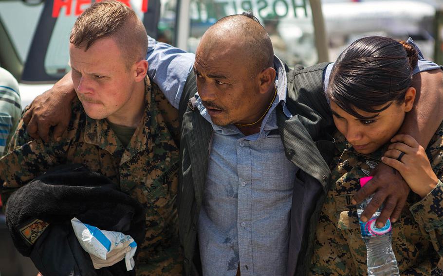 U.S. Marine Corps Lance Cpl. John Kingwell and U.S. Navy Hospital Corpsman 2nd Class Jessica Gomez, both with Joint Task Force 505, help an earthquake victim to an ambulance at a medical triage area at Tribhuvan International Airport, Kathmandu, Nepal, May 13, 2015, after a 7.3 magnitude earthquake struck the country.