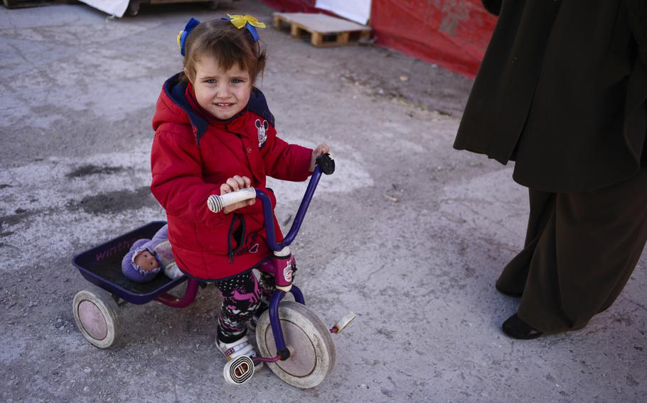 A girl whose family was displaced by the war in eastern Ukraine, rides a tricycle at a refugee center set up in Kiev, April 22, 2015.