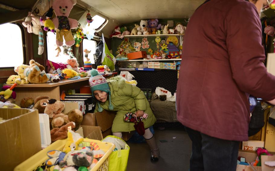 A girl whose family was displaced by the war in eastern Ukraine looks for toys at a center set up to aid refugees, Kiev, Ukraine, April 22, 2015.