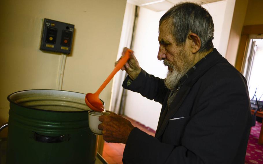 An elderly man scoops water into his cup on April 23, 2015, at the Dzherelo center, an old retreat in Pushcha Vodytsya, Ukraine,that was converted into housing for those displaced by the war in the east.