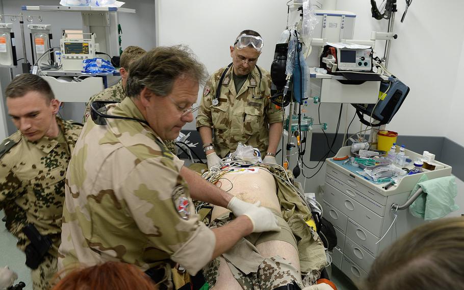 Dutch and German doctors evaluate a simulated casualty at a German military hospital at Train, Advise and Assist Command-North as part of ongoing combat drills to prepare for Afghanistan's spring fighting season.
