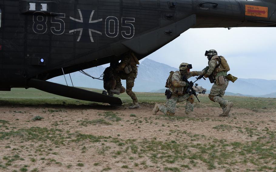 A Georgian soldier provides cover as members of  Train, Advise and Assist Command-North's Quick Reaction Force clamor onto a German helicopter during a March 31, 2015, air-assault drill in Afghanistan's Balkh province.