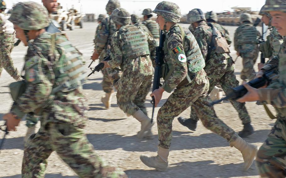 Afghan soldiers with the army's 215 Corps sprint to their Humvees and armored personnel carriers ahead of a patrol May 12, 2015 at Camp Shorabak in Helmand province. This is the first fighting season for the soldiers without coalition forces in the province.