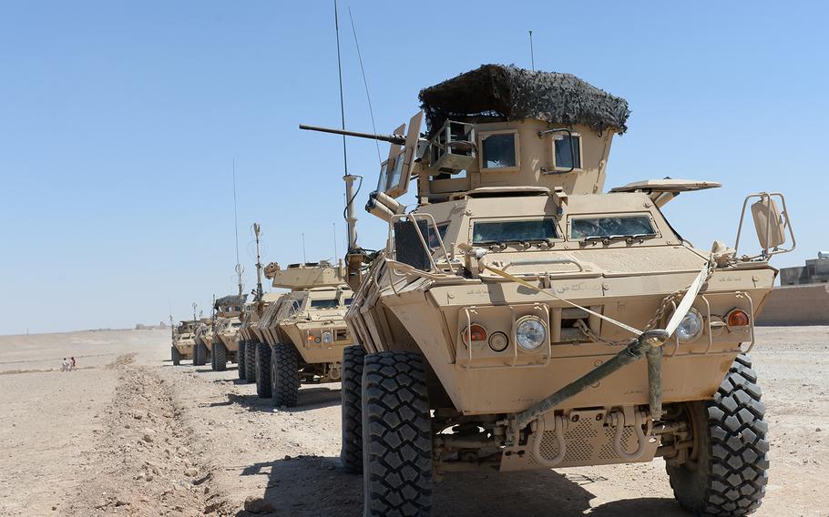 A row of armored personnel carriers sits idle outside the town of Gereshk in Helmand province during what turned out to be a faux Afghan army patrol, May 12, 2015. Officials said they lack the resources to continue the type of counterinsurgency patrols common during the coalition's presence in Helmand.