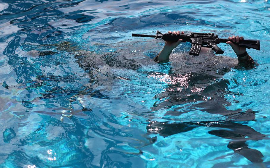 Master Sgt. Vincent Marzi, the operations chief for 1st Reconnaissance Company, rises from the water with his rifle during an aquatic event during the 7th Annual Recon Challenge aboard Marine Corps Base Camp Pendleton, California, May 15, 2015.
