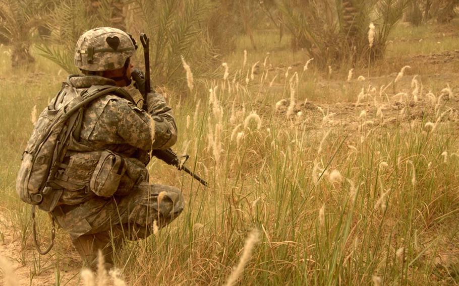 In this image taken by 55th Combat Camera, a U.S. Army soldier radios to his fellow soldiers while searching for weapons caches in northwest Shulla, Iraq, May 16, 2008.  Three combat camera troops have been killed while covering the troops fighting in Iraq and Afghanistan.

