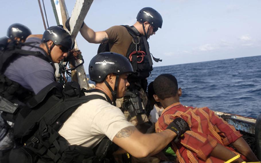 In this photo taken by a combat camera servicemember, U.S. Navy and Marine Corps visit, board, search and seizure team members stationed aboard the guided missile cruiser USS San Jacinto guard suspected pirates on board a dhow on the Gulf of Aden, May 27, 2010. Photographs and video taken by combat camera troops are often released to the public and might show up in local newspapers or on television.

