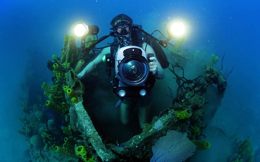 Mass Communication Specialist 1st Class Shane Tuck films coral growth in the pilot house of a sunken naval landing craft off the coast of Guantanamo Bay, Cuba, Feb. 9, 2012. Expeditionary Combat Camera's Underwater Photo Team conducts semi-annual training to hone its divers' specialized skill set and ensure valuable support of Department of Defense activities worldwide.

