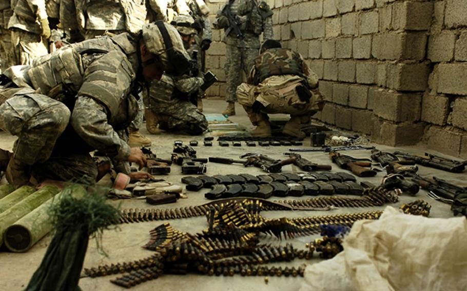 A coalition soldier and Iraqi army soldier count materials found in a large weapons cache in 2006 in Hawija, Iraq, in this combat camera photo. The 700 active-duty troops assigned to combat camera learn combat skills and small unit tactics to allow them to integrate with ground combat forces.



