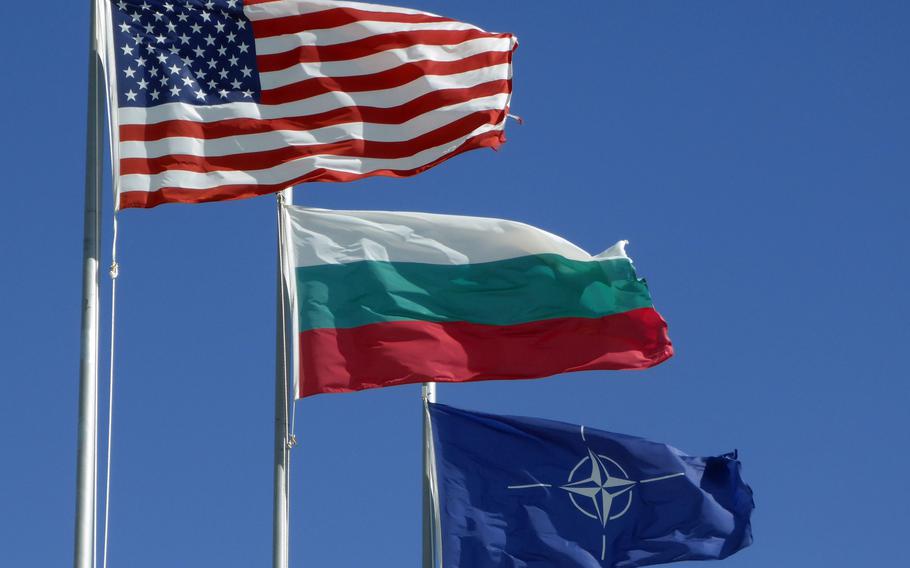 The American, Bulgarian and NATO flags fly over the American headquarters building at the Novo Selo Training Area, Bulgaria, June 26, 2015. The United States signed a defense cooperation agreement with Bulgaria in 2006 to use its military bases, two years after Bulgaria joined NATO.