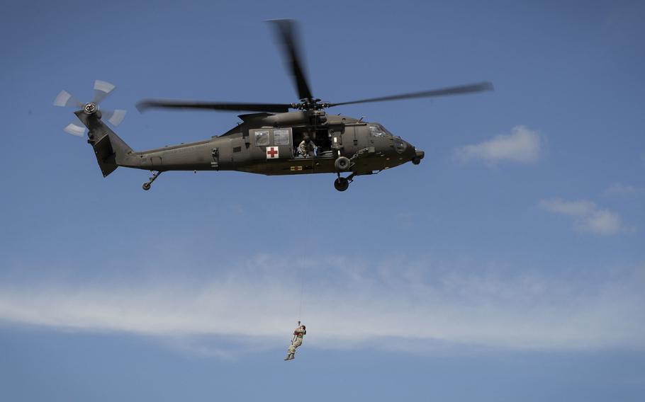 Airman 1st Class Natalie Powell, a 1st Combat Camera Squadron combat broadcaster, is hoisted up on a UH-60 Black Hawk medevac helicopter during a training evacuation at Fort McCoy, Wisc., on June 12, 2015.