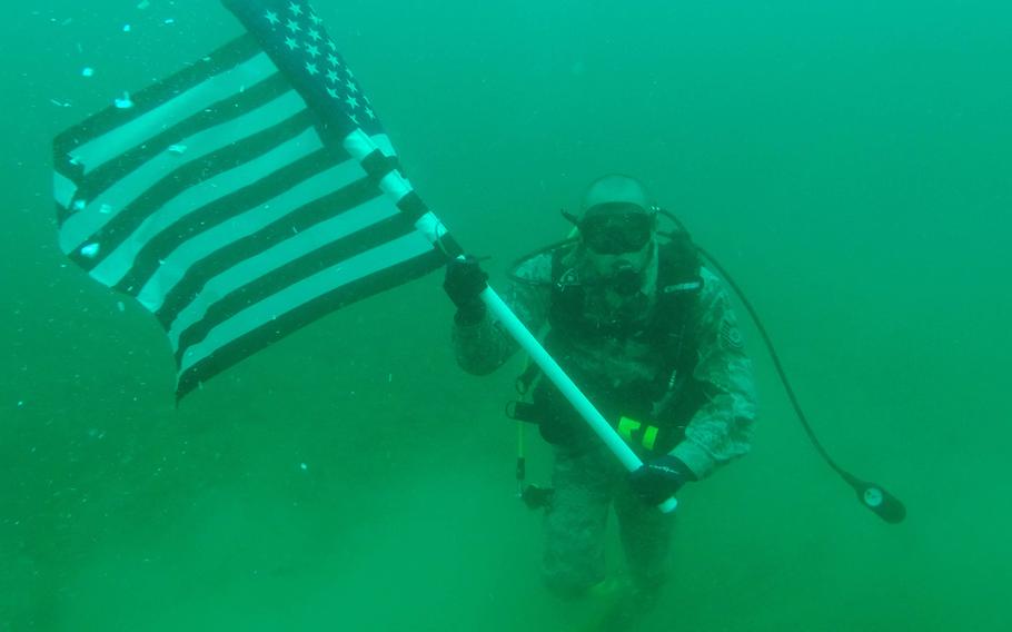 Tech. Sgt. Robert Barnes, 325th Communications Squadron quality assurance NCO in charge, holds the U.S.flag on June 26, 2015. Barnes had a re-enlistment ceremony 70 feet under water.