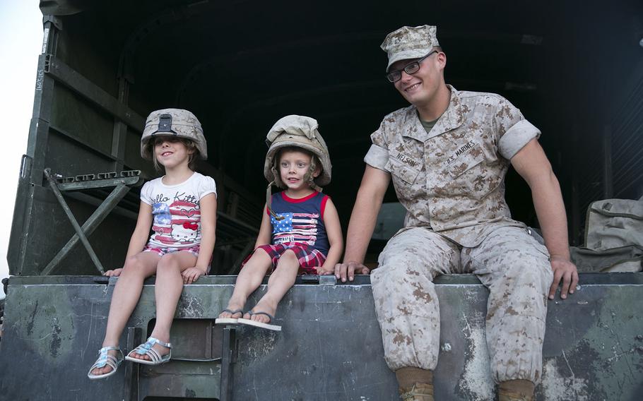 Pvt. Christopher Nelson, field artillery cannoneer, sits in a Medium Tactical Vehicle Replacement with Gracie Lynn Sandefur, 7, and Bentley Sandefur, 5, at the Community Center Park during the Yucca Valley Independence Day Celebration, July 4, 2015.