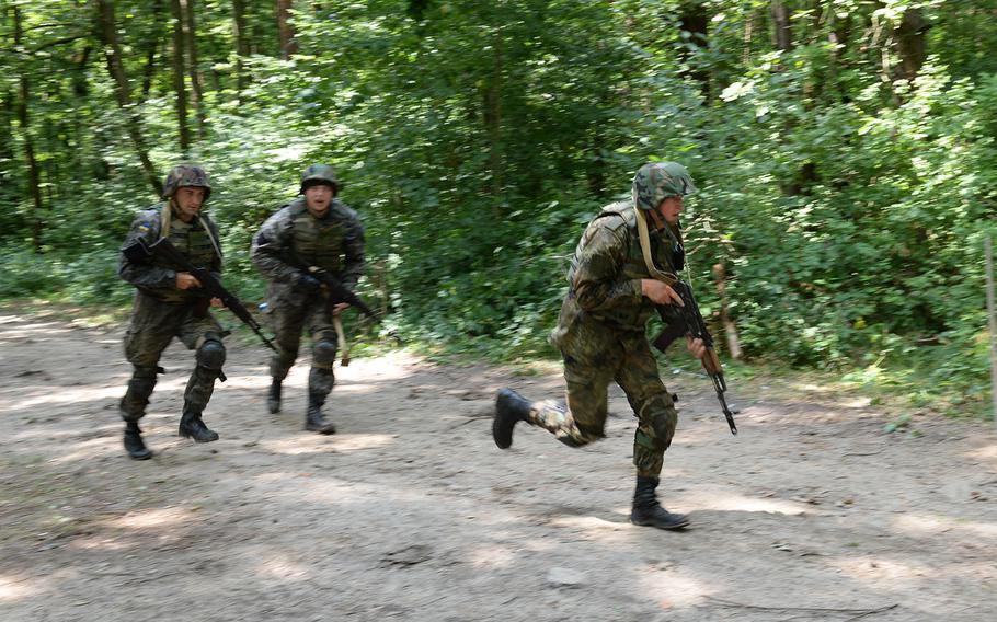 Ukrainian national guardsmen run across a simulated danger area July 9, 2015, at a training facility in Yavoriv, Ukraine. Since April, about 300 American paratroops have been training Ukrainian soldiers to fight against Russian-backed separatists in eastern Ukraine.