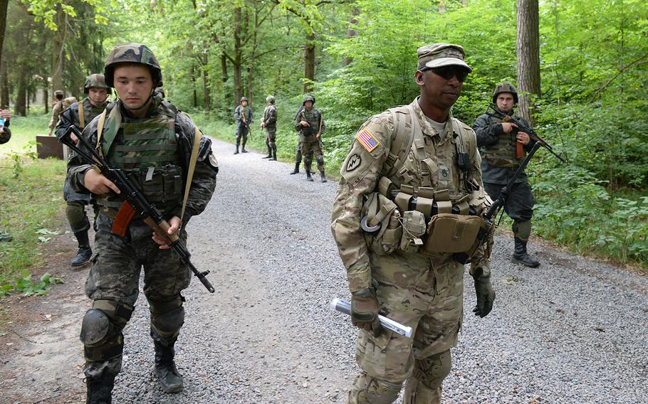 U.S. Army Staff Sgt. Gregory Simmons, center, supervises Ukrainian national guardsmen on  a simulated patrol July 9, 2105 at a training facility in Yavoriv, Ukraine. The Pentagon is considering a plan to expand the training mission to include Ukrainian army soldiers.