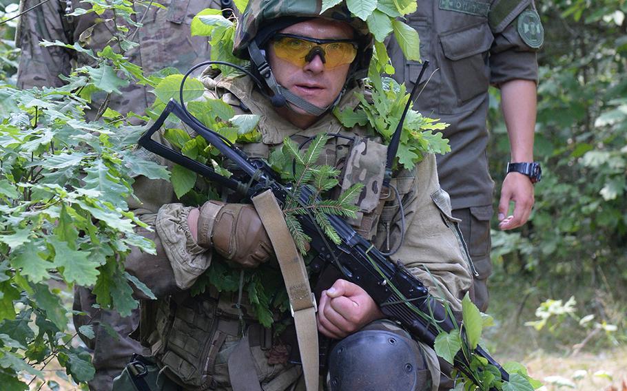 Cpl. Colt Smith, left, a paratrooper with the 173 Airborne Brigade Combat Team, and a Ukrainian translator stand behind a Ukrainian national guardsman undergoing training during a patrol July 9, 2015, at a training facility in western Ukraine.