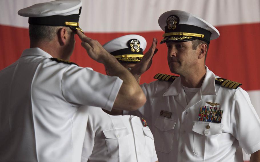 Capt. Daniel C. Grieco, outgoing commanding officer, left, salutes Capt. Craig A. Clapperton, incoming commanding officer, right, for the aircraft carrier USS Theodore Roosevelt during a change of command ceremony  in Bahrain Tuesday, July 21, 2015.