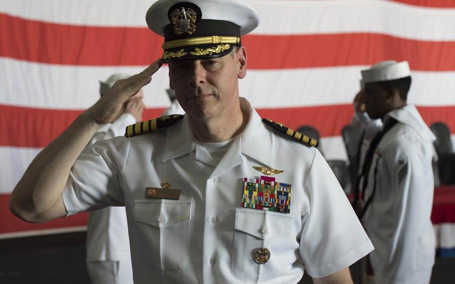 Capt. Daniel C. Grieco, USS Theodore Roosevelt's outgoing commander, salutes as he's ceremoniously rung off the aicraft carrier one last time Tuesday, July 21, 2015.  Commanding Officers are rung on and off their ship as they arrive and depart.  The Roosevelt and its carrier strike group both got new commanders Tuesday during a ceremony in Bahrain.