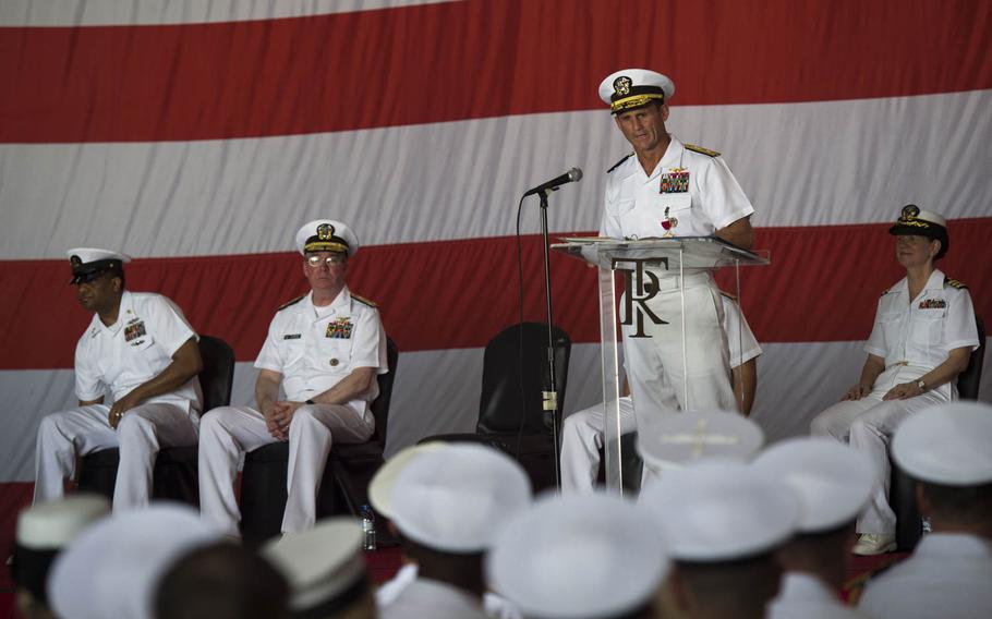 Rear Adm. Andrew L. Lewis, outgoing commander of the Roosevelt carrier strike group, makes remarks during a change of command ceremony aboard the aircraft carrier USS Theodore Roosevelt Tuesday, July 21, 2015.  The Roosevelt and its carrier strike group both got new commanders while the ship is in Bahrain on a short break from an eight-month deployment in the Middle East.