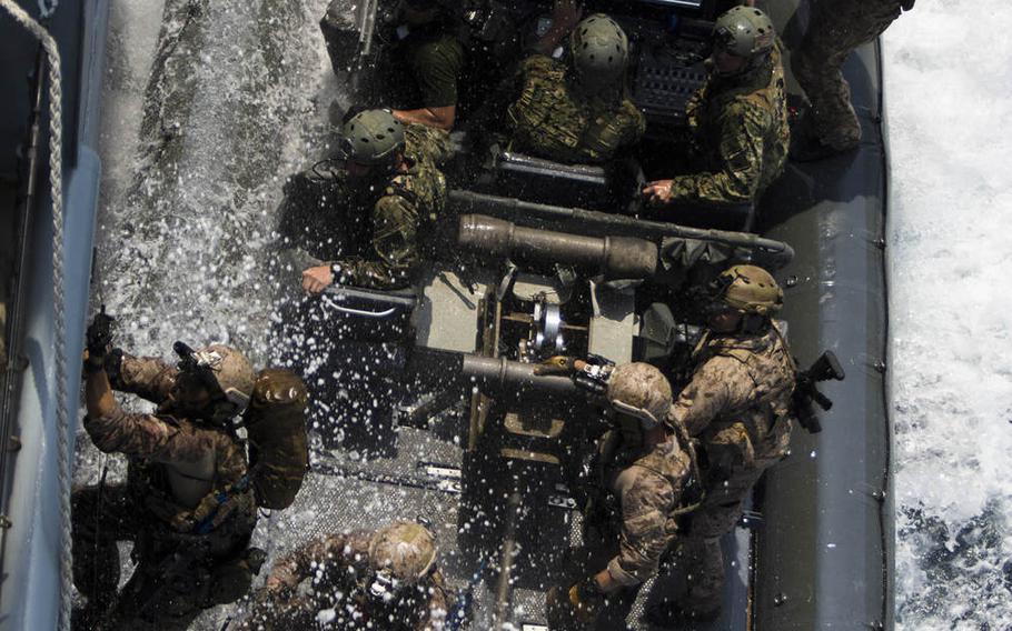 U.S. Navy SEALs board a ship from a Rigid-Hull Inflatable Boat as they conduct a joint Visit, Board, Search, and Seizure exercise alongside U.S. Marines assigned to Force Reconnaissance Platoon, Maritime Raid Force, 26th Marine Expeditionary Unit, during composite training unit exercise in the Atlantic Ocean, July 20, 2015.