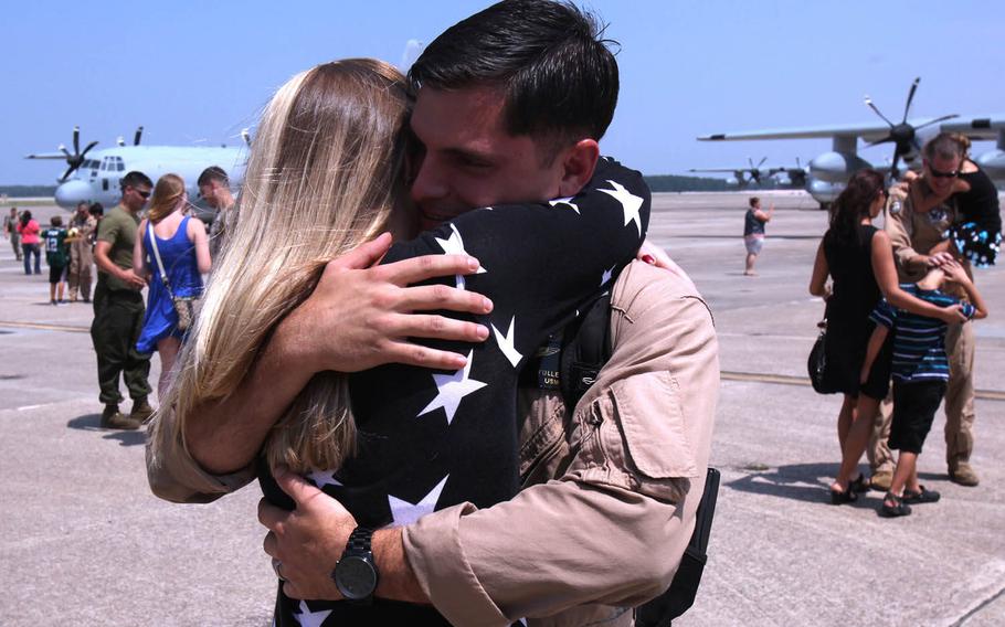 Cpl. Christopher Fuller, a crew chief with Marine Aerial Refueler Transport Squadron 252, embraces his wife, Jessica Fuller, during a return celebration for the Marines of VMGR-252 at Marine Corps Air Station Cherry Point, N.C., July 20, 2015.