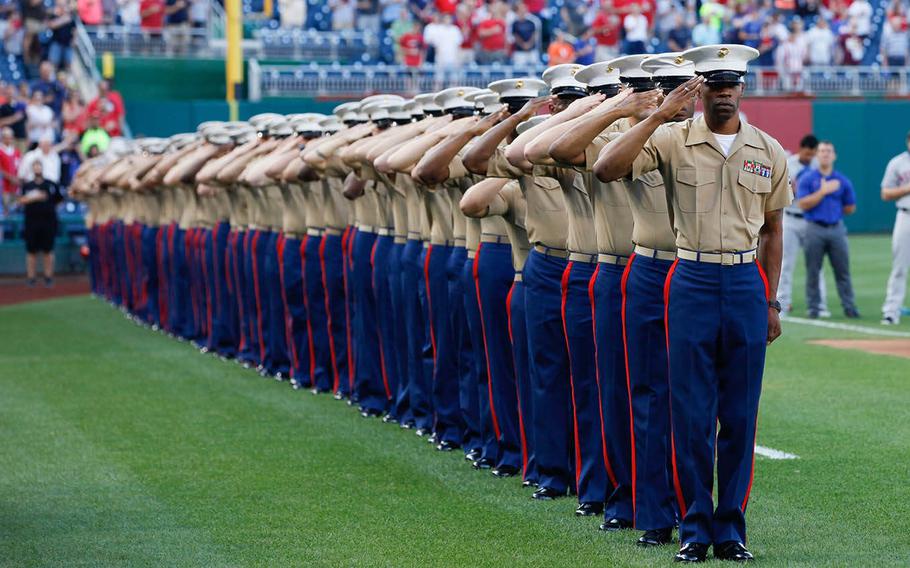 Marines from the National Capitol Region salute during the playing of the National Anthem, July 21, 2015, at Nationals Park in Washington. The Washington Nationals hosted a Marine Corps Day to honor Marines who serve and who have served in the past.