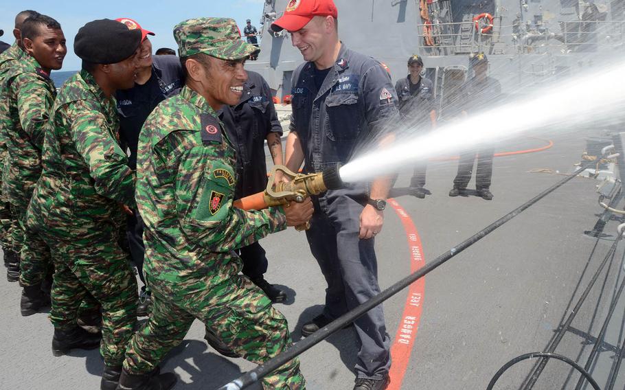 U.S. sailors help members of East Timor's Defense Force work on fire hose-handling skills aboard the guided-missile destroyer USS Kidd during 2014 Cooperation Afloat Readiness and Training (CARAT) in East Timor. About 150 U.S. sailors have arrived in East Timor for this year's CARAT exercise. Sailor will train East Timor servicemembers on basic seamanship, while Seabees will work on community service projects.