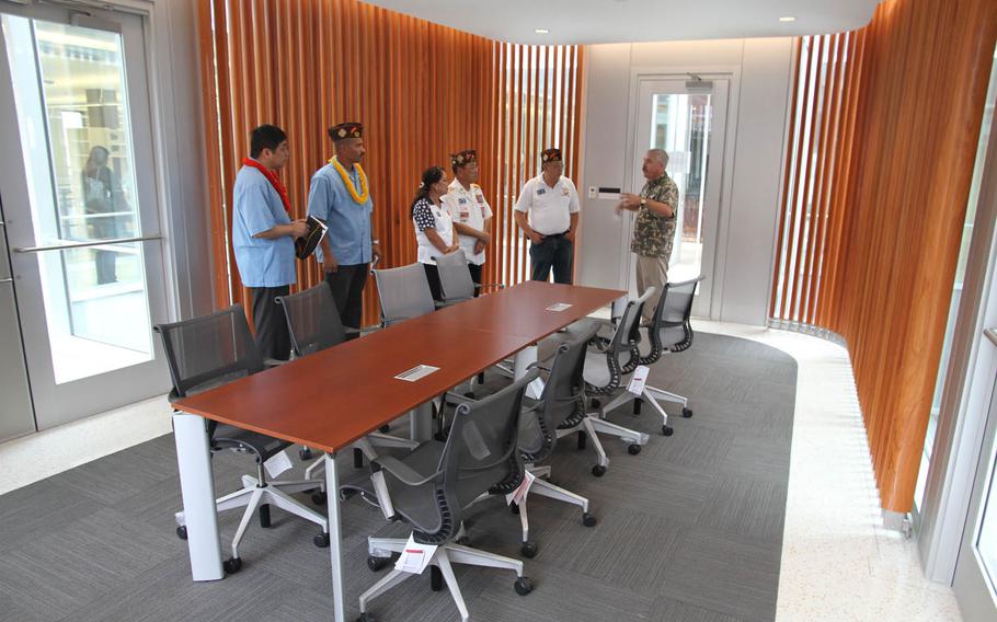 A Defense POW/MIA Accounting Agency representative tells visitors about the family viewing room at the agency's new lab, which serves as a centerpiece of the three-story building.