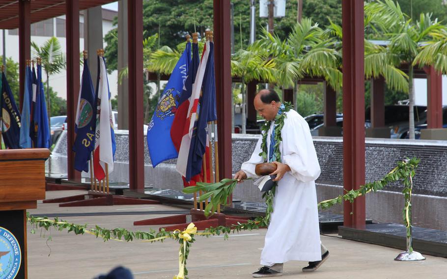 The Rev. Kahu Kordell Kekoa blesses the maile lei before guests untied it Monday, July 27, 2015, during the dedication ceremony of the Sen. Daniel K. Inouye DPAA Center of Excellence at Joint Base Pearl Harbor-Hickam in Hawaii.