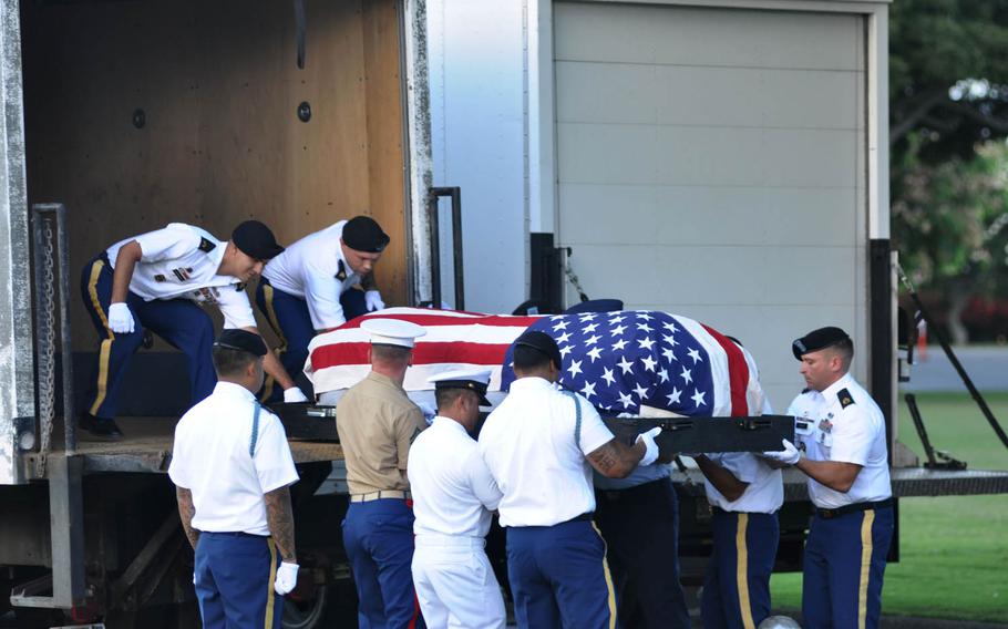 A casket holding the remains of sailors and Marines killed on the USS Oklahoma is lifted onto a truck Monday, July 27, 2015, in Honolulu during a dignified transfer ceremony.