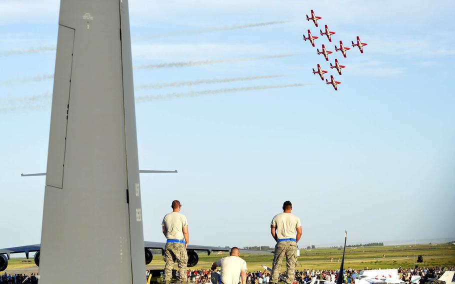 Airmen from the 415th Special Operations Squadron stand on top of a C-130 Hercules to watch the Royal Canadian Forces Snowbirds perform on Friday, July 24, 2015, in Lethbridge, Alberta province, Canada. The C-130 static display and Snowbird performance were part of the 2015 Lethbridge International Airshow.
