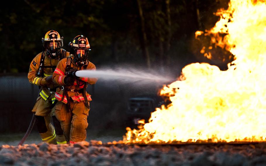 Members of the 122nd Fighter Wing Fire Department, from the 122nd Fighter Wing in Fort Wayne, Ind., battle a simulated aircraft fire on Wednesday, July 22, 2015, at the Combat Readiness Training Center in Alpena, Mich.