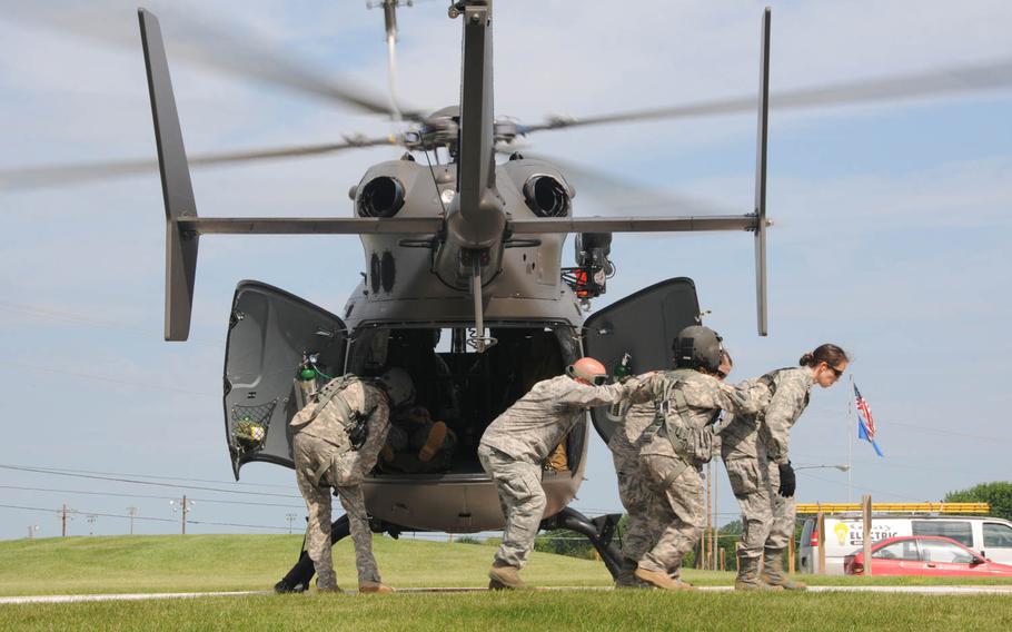 Army and Air National Guardsmen carefully exit the helicopter pad at the Mile Bluff Medical Center, Mauston, Wis., on Wednesday, July, 22, 2015, after loading a patient into a Wisconsin Army National Guard UH-72A Lakota Light Utility Helicopter. These Guardsmen, along with about 50 Mile Bluff staffers, participated in PATRIOT Exercise 2015, a domestic operations exercise that tested and trained military and civilian first responders on their natural disaster response.