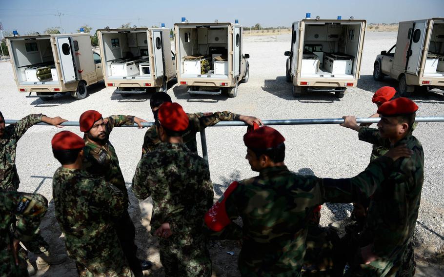 Army ambulance crews wait by their vehicles at a helicopter landing zone at a base in Mazar-e-Sharif, Afghanistan on Oct. 6, 2015. The vehicles were used to carry both wounded soldiers and coffins, and all would be filled in a matter of hours.