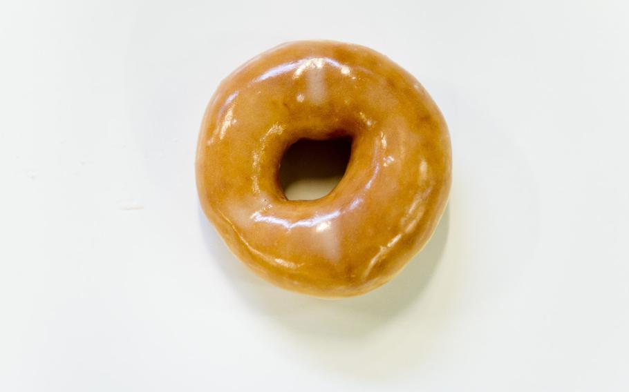 A Krispy Kreme doughnut travels down the conveyor belt at the Exchange Bakery Europe in Gruenstadt, Germany, on Monday, Nov. 9, 2015.